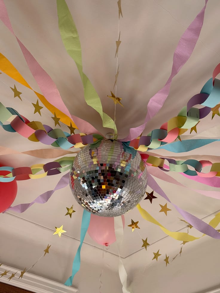 Disco ball hanging among colourful streamers and paper chains